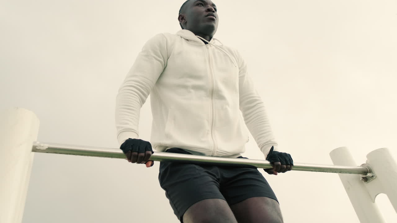 Determined Young Man Doing Calisthenics on a Beach