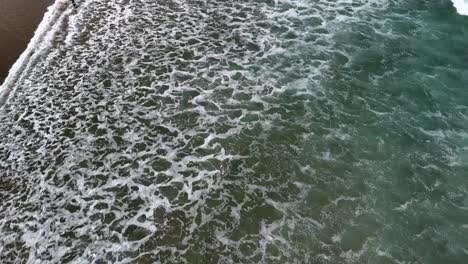 reveal aerial shot of a famous beach in devon, england with holiday makers enjoying a sunny day out