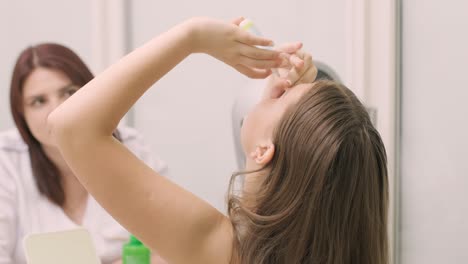 어린 소녀는 눈과 의사 사무실에서 야간 콘택트 렌즈를 설치하기 전에 눈방울을 주입합니다. 눈방울은 액체를 열린 눈에 넣습니다. 아이의 눈방울.