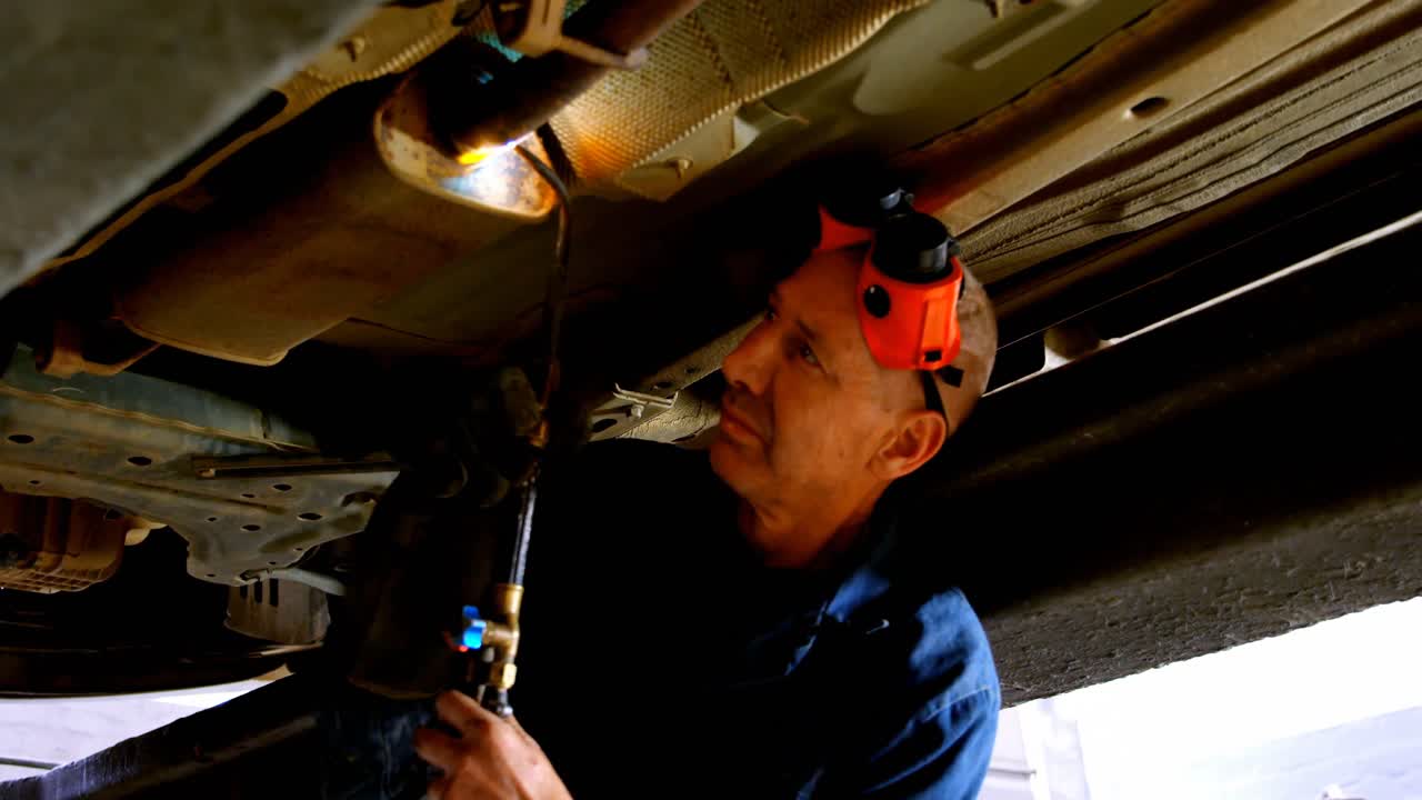 mecánico usando una antorcha en un coche 4k