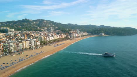 Passenger-boat-on-the-beach-of-the-Costa-Brava,-aerial-images-of-Lloret-De-Mar