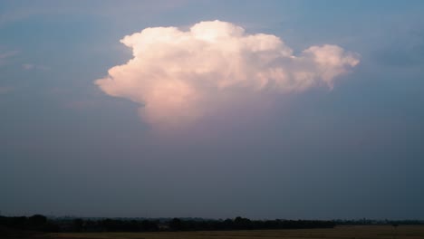 Eine-Wogende-Einzelne-Wolke-Steigt-über-Dem-Dunstigen-Horizont-Auf-Und-Wird-Flacher