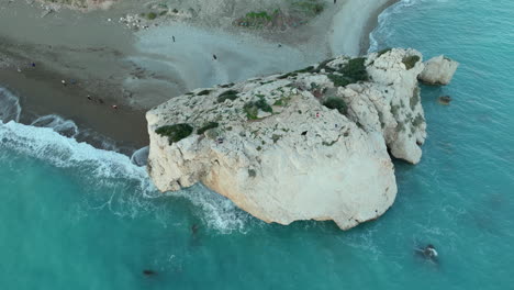 Aerial-view-of-a-large-rock-formation-by-a-beach-with-turquoise-waters