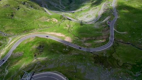 Vista-De-Arriba-Hacia-Abajo-De-La-Famosa-Carretera-De-Montaña-Transfagarasan-Que-Cruza-Las-Montañas-De-Los-Cárpatos-En-Rumania,-Vista-Aérea-De-Una-Hermosa-Cordillera-Con-Picos-Altos