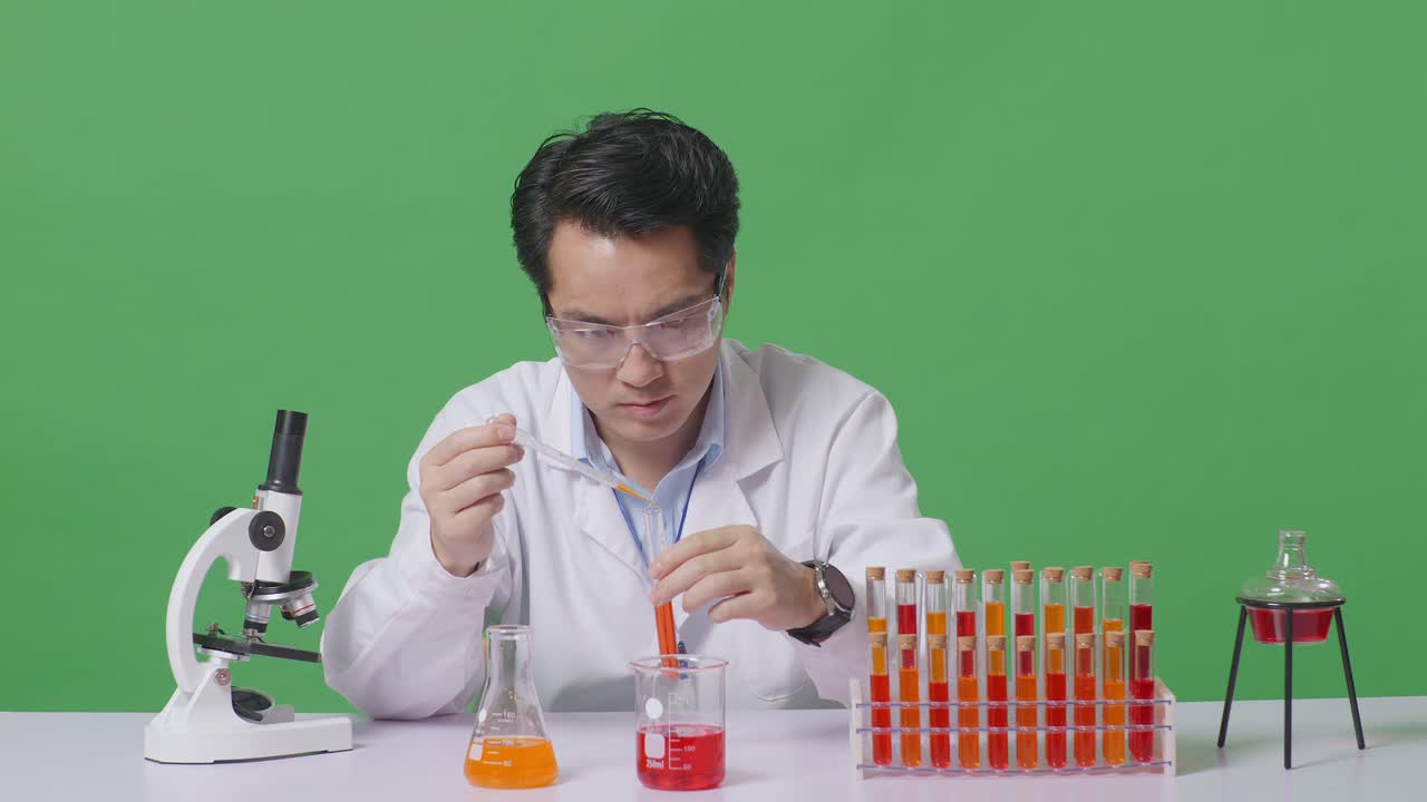 Asian Man Scientist Making Experiment With Test Tube And Screaming Goal Celebrating While Working On The Table With Microscope In The Green Screen Background Laboratory