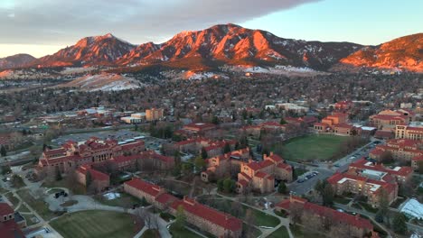 beautiful aerial drone sunrise over the university of colorado boulder with flat irons foothill mountains in background on a winter morning