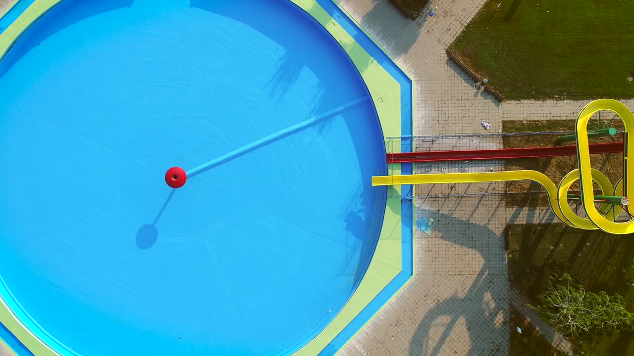 vista aérea de una piscina vacía con toboganes en un parque acuático abandonado.
