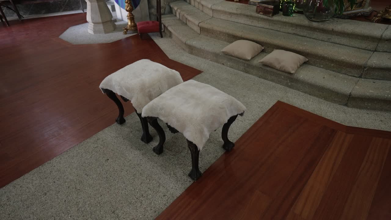 Two wedding kneeling stools and altar cushions arranged in quiet church space