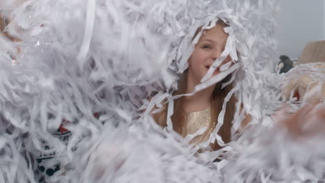 children having fun in heap of paper confetti