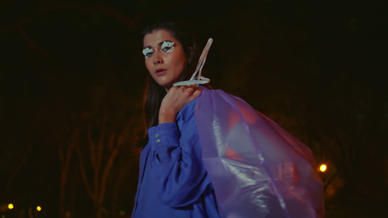 chica posando limpieza del parque bajo luz de linterna nocturna primer plano. mujer con pestañas