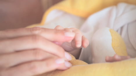 mujer levantando la mano de su bebé y besándola