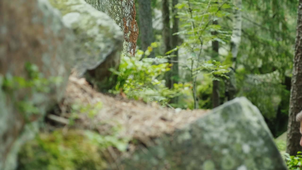 un hombre decidido con una mochila sube a un concepto de roca: la búsqueda de un objetivo 4k video