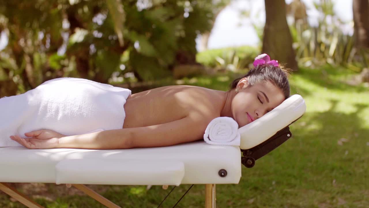 una mujer joven relajándose en un spa al aire libre.