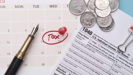 tax day concept with red circle on calendar date and tax return on table