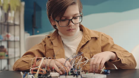young student building electronic circuits
