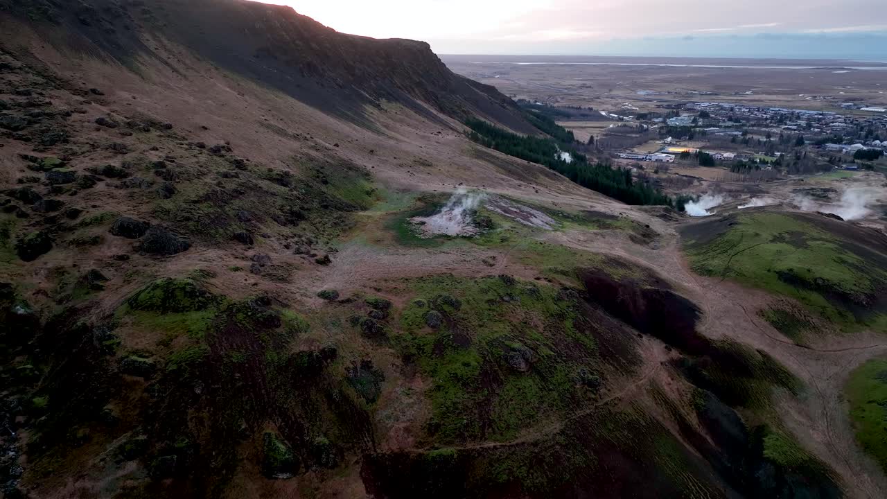 colinas humeantes cerca de la ciudad de hveragerdi en el sur de islandia - toma aérea de drones