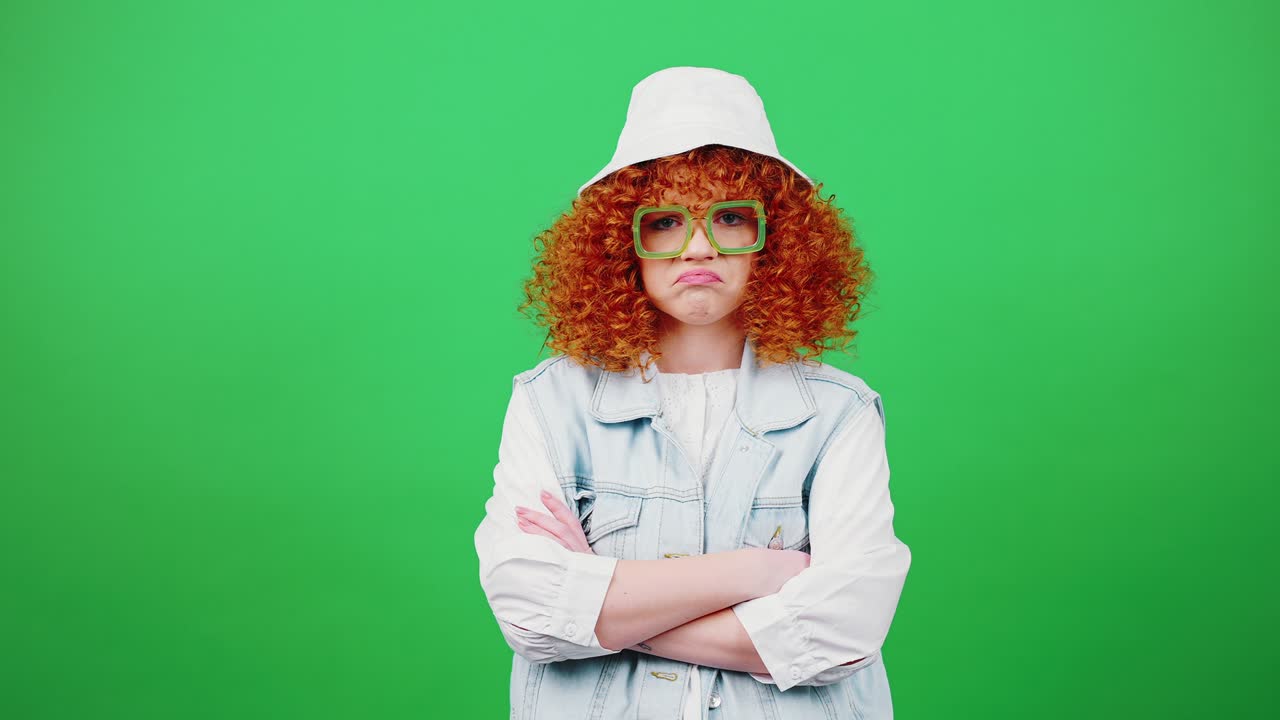 젊은 은 머리, 곱슬 머리, 안경과 파나마 모자를 입은 여성, 상처를 느끼고, 팔을 접고 입술을 히고