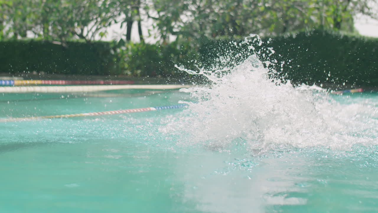Black Man Swimming Butterfly Stroke in Outdoor Pool