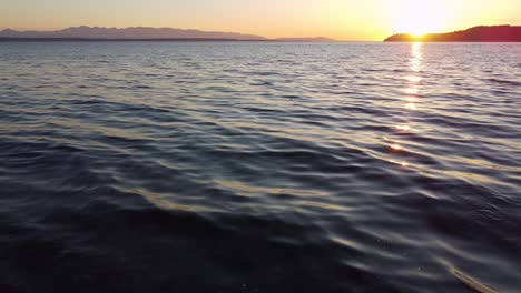 Flying-over-the-water-along-the-puget-sound-at-sunset,-Edmonds,-Washington-State