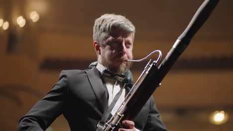 bassoon player is performing solo in classic music concert adult talented man with bassoon