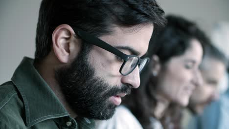 vista lateral de un hombre enfocado con gafas trabajando