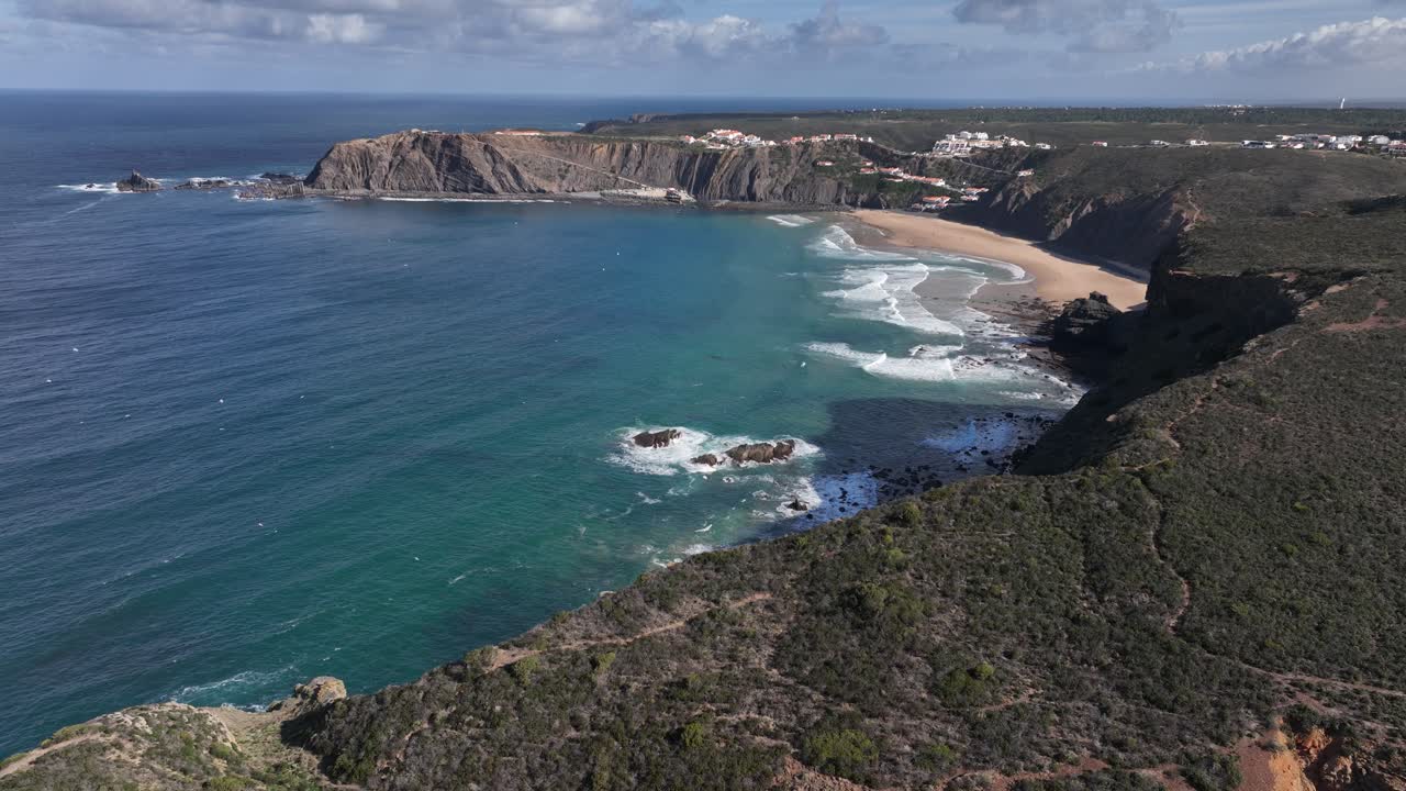 바다 옆의 아름다운만을 둘러싼 녹색 절벽 위로 날아가는 공중 샷