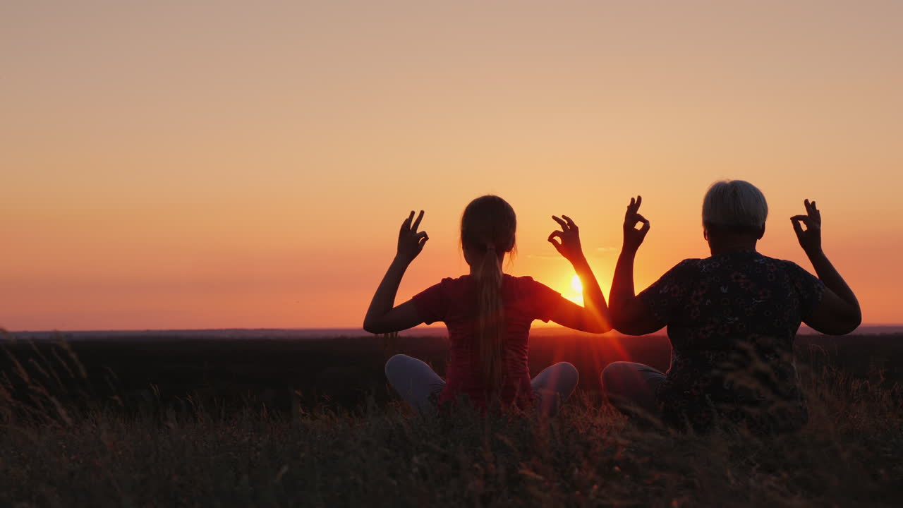 anciana con su nieta admirar la puesta de sol en un lugar pintoresco