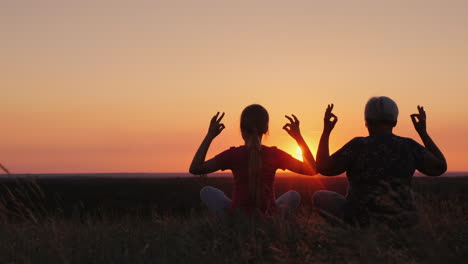 elderly woman with her granddaughter admire the sunset in a picturesque place