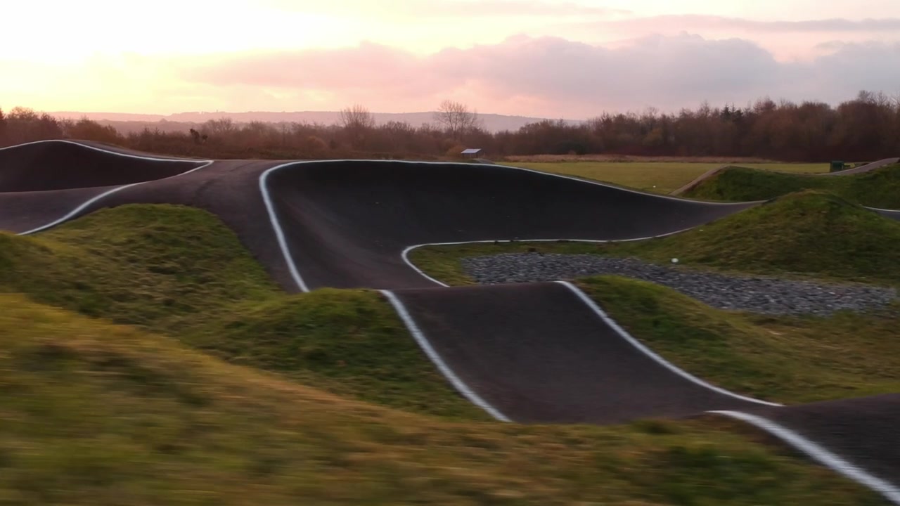 Người trượt ván điện lướt quanh đường đua BMX pump track.
