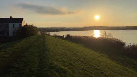 countryside rural sunset scene with lake a terraced house and golden tones