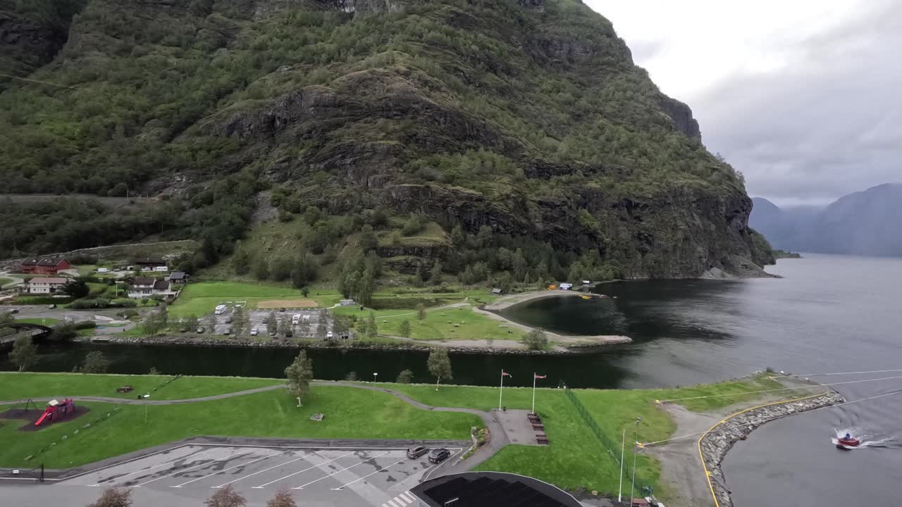 n time-lapse, the mountain shadows shift and water glows while Flam’s small village and winding road sit still beneath the changing sky