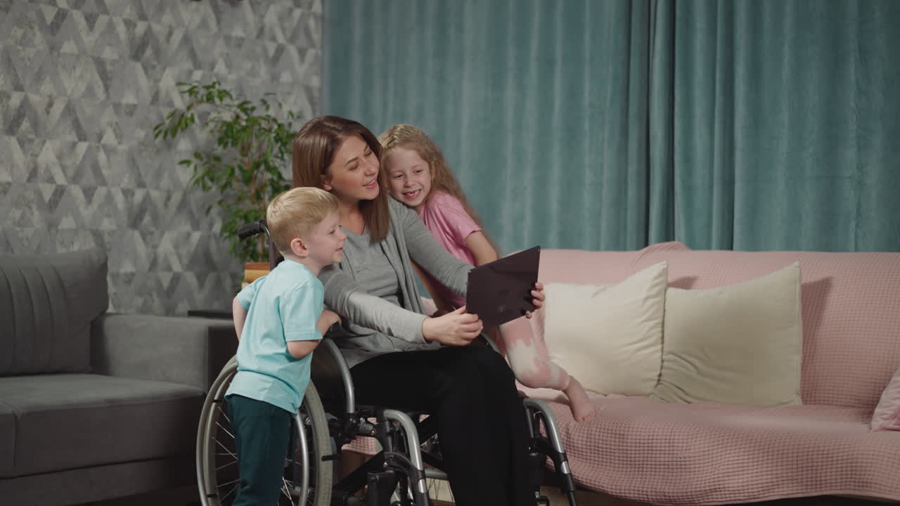los niños se acurrucan con la mamá en silla de ruedas para hacer una linda selfie
