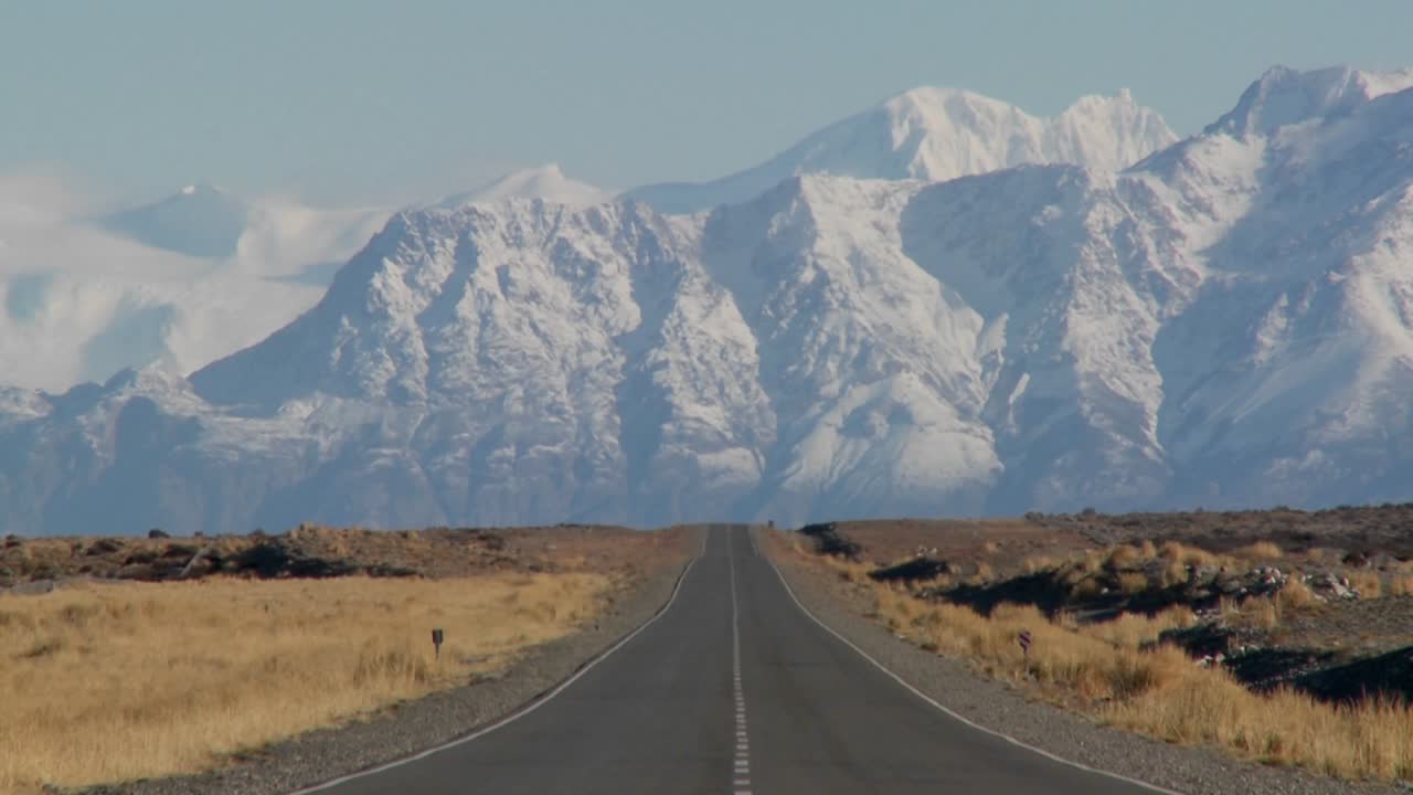 An empty road heading into the Andes mountains in the rmote Argentine region of Patagonia