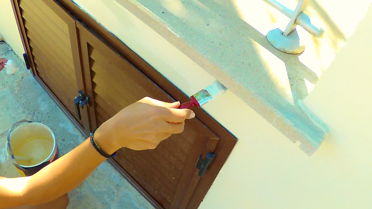 Female Painter Painting the walls outside