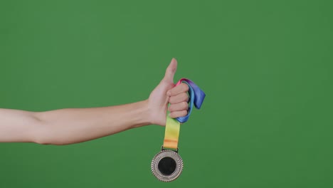 무지개 리본 을 가진 은메달 을 들고 있는 손