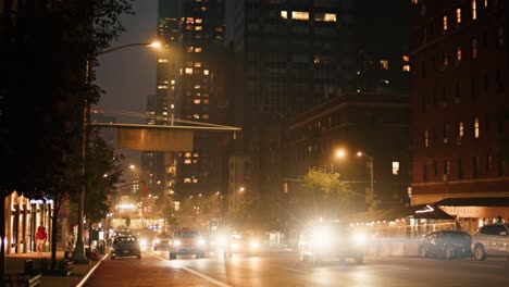 traffic drives past camera in a smoke covered new york city at night