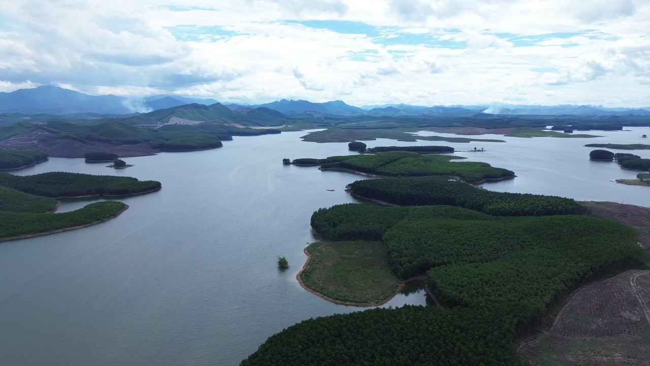 Aerial zoom in reveals water, trees and remote islands under bright skies