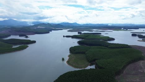 aerial zoom in reveals water, trees and remote islands under bright skies