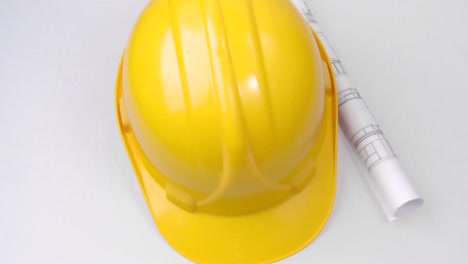 High-view-of-a-yellow-hard-hat-and-a-plan-turning