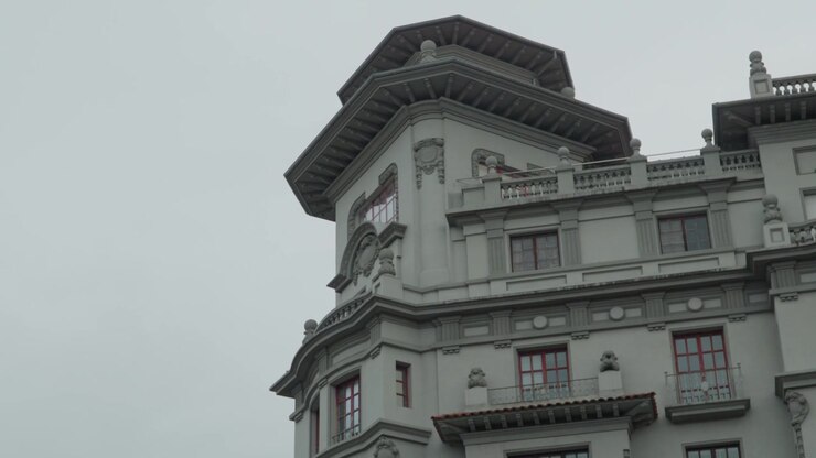 Dettagli architettonici ornati di un edificio storico contro un cielo nuvoloso a Oviedo, Spagna