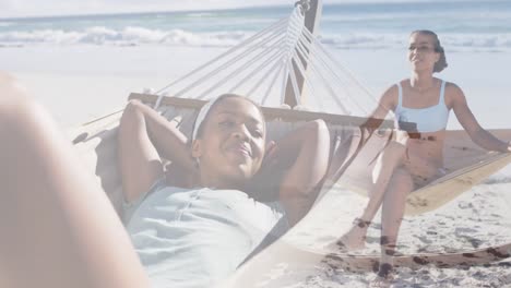 animation of happy african american woman in hammock on beach