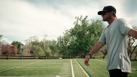 a side shot of a professional male baseball player practices tossing a ball into the air and hitting it