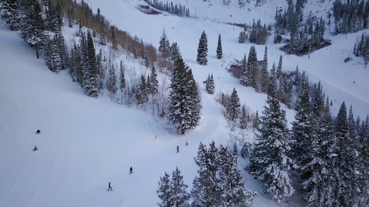 Sciatori e snowboarder scendono a tutta velocità lungo il fianco di una montagna innevata nello Utah.