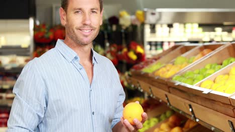hombre recogiendo frutas en el supermercado