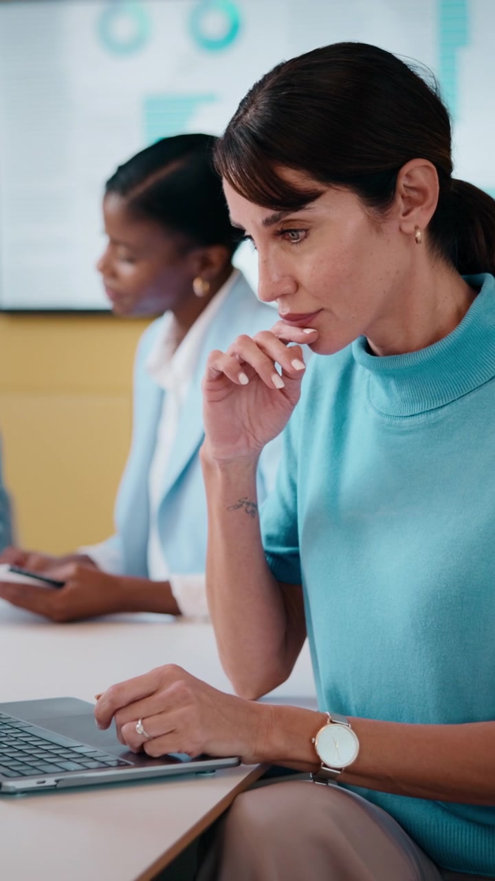 Donna professionista che lavora al laptop durante una riunione in un ufficio moderno
