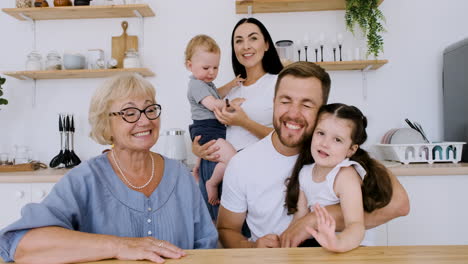 familia feliz mirando la cámara mientras hace una videollamada en la cocina