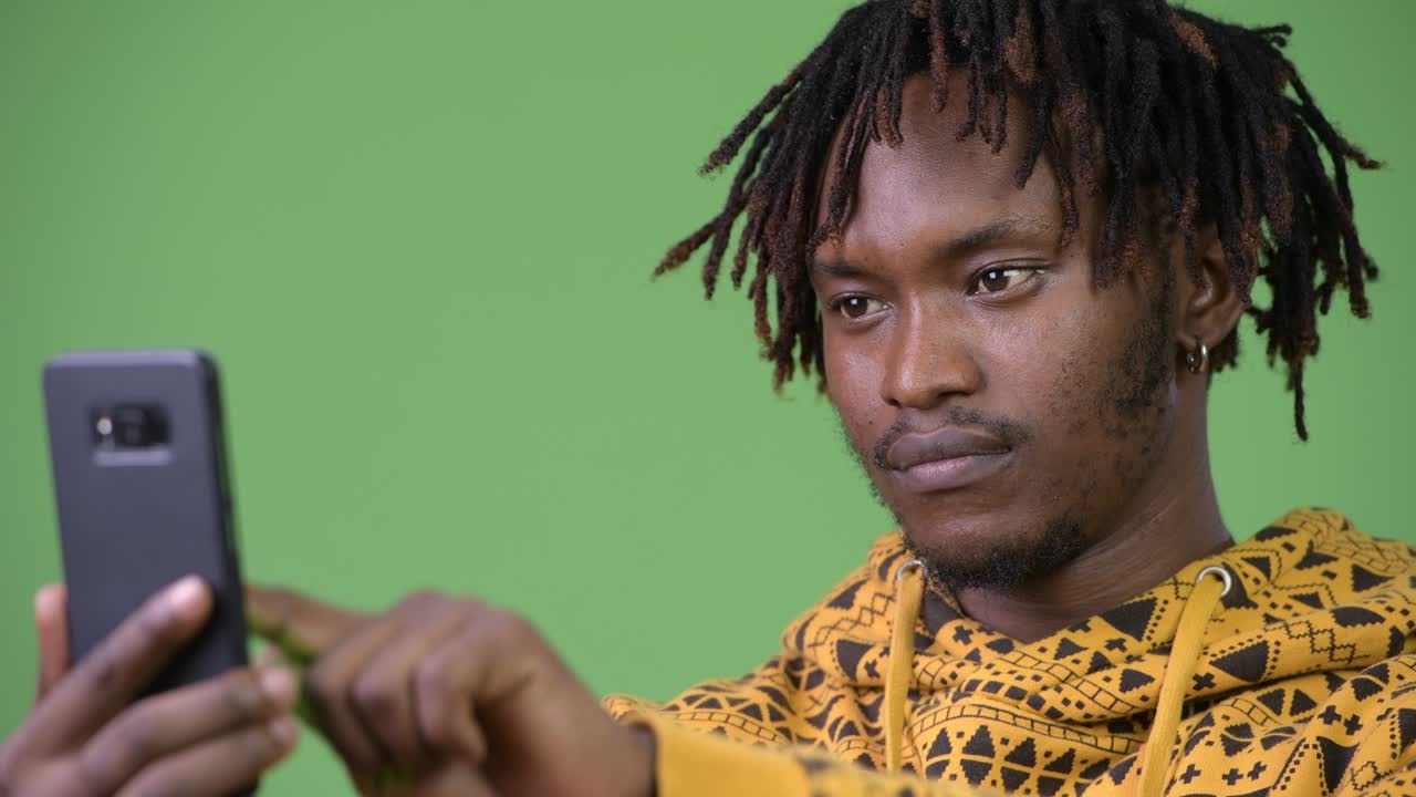 Young handsome African man using phone