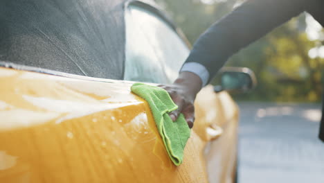 person washing a yellow convertible car