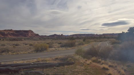 Erhebt-Sich-über-Einem-Gewundenen-Wacholderbaumstumpf-In-Der-Wüste-Von-Utah-Neben-Der-Offenen-Straße