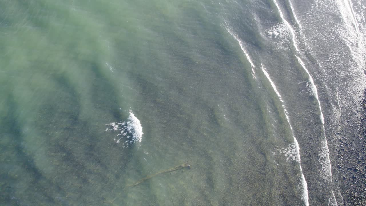 호주 퀸즐랜드 케이프 트러블레이션에 있는 거품 파도와 자갈 해안이 있는 산호 바다의 맑고 푸른 바닷물